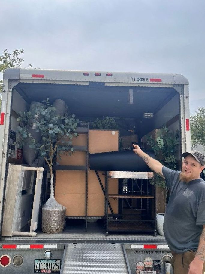 A man is standing in front of a moving truck.