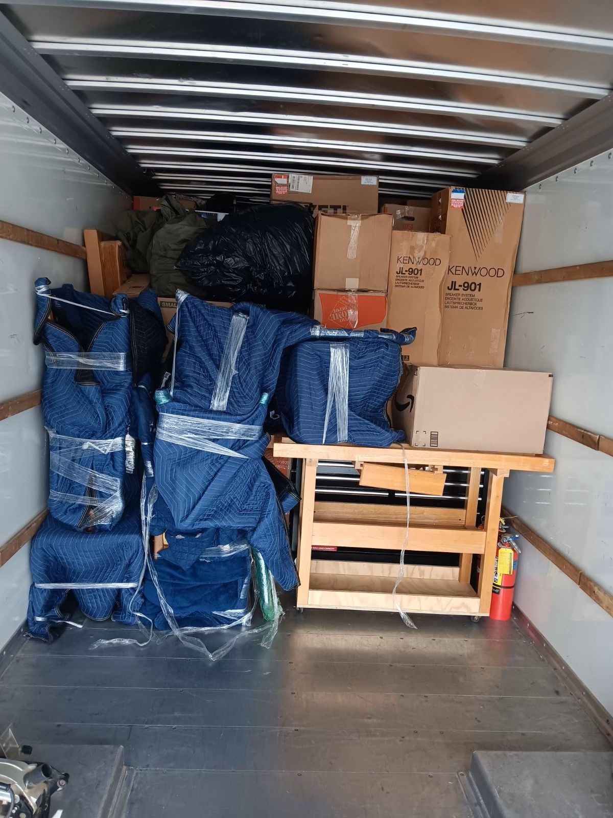 The inside of a moving truck filled with boxes including one that says lg