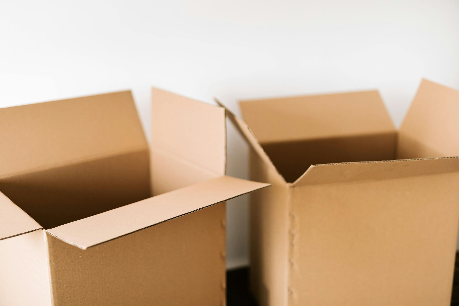 Two cardboard boxes are open and sitting next to each other