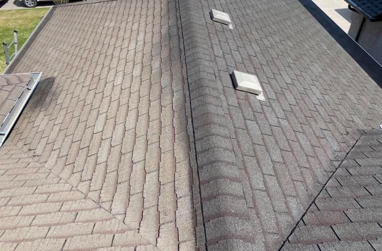 A close up of a roof with a car parked in the background