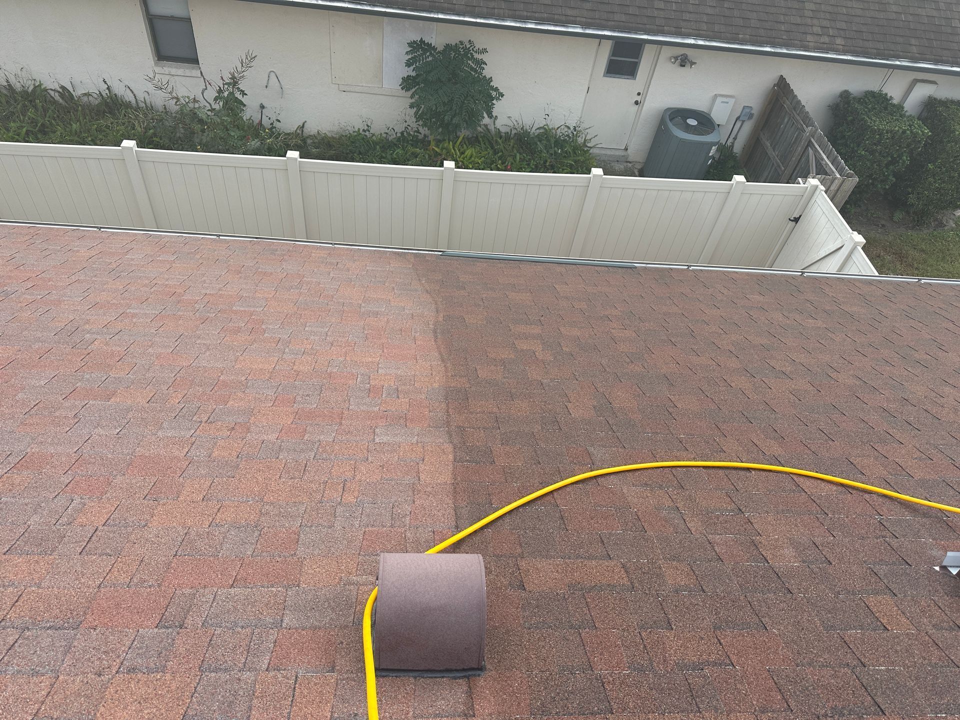 An aerial view of a roof with a yellow hose attached to it.