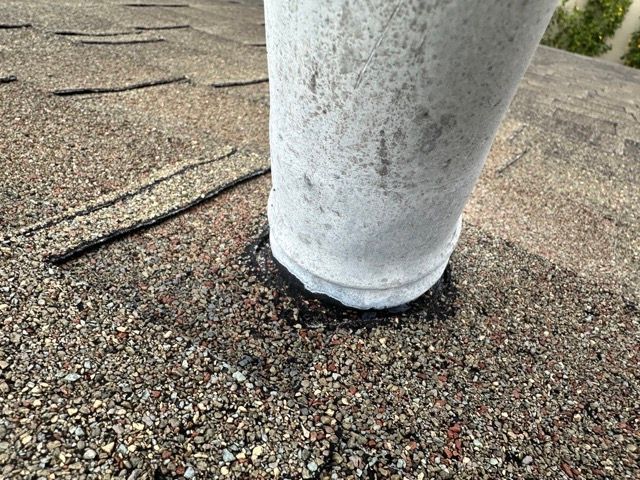 A white pipe is sitting on top of a roof.