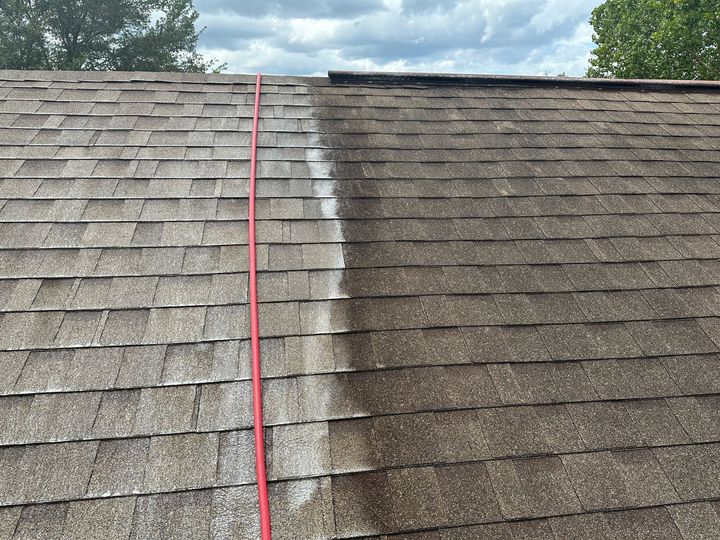 A before and after picture of a roof being cleaned with a hose.