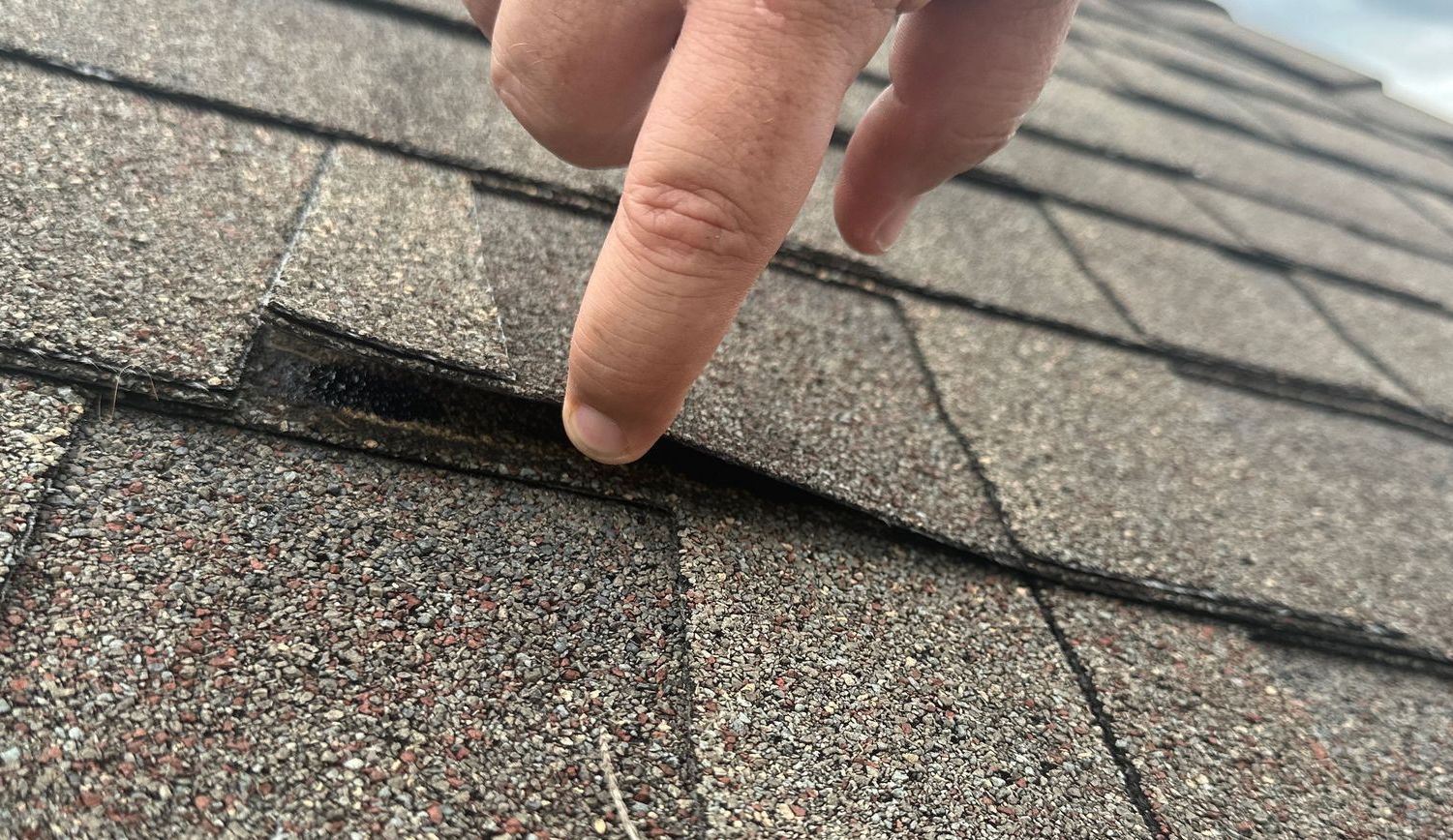 A person is pointing at a roof with their finger.