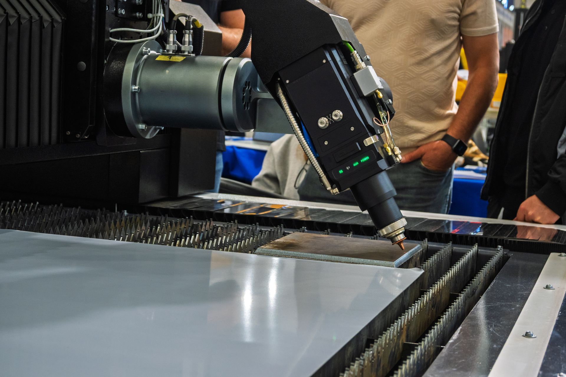 A laser cutting machine carving patterns on a plastic plate.