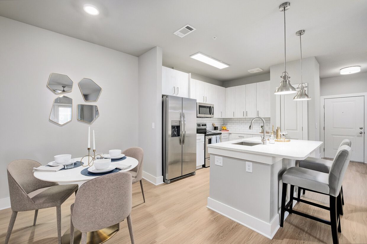 A kitchen and dining room in a house with a table and chairs.