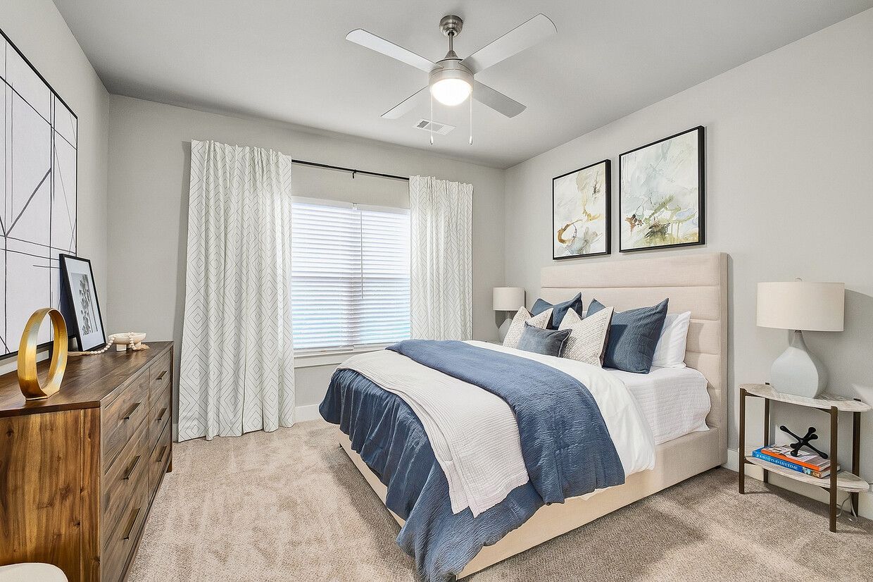 A bedroom with a bed , dresser , nightstand and ceiling fan.