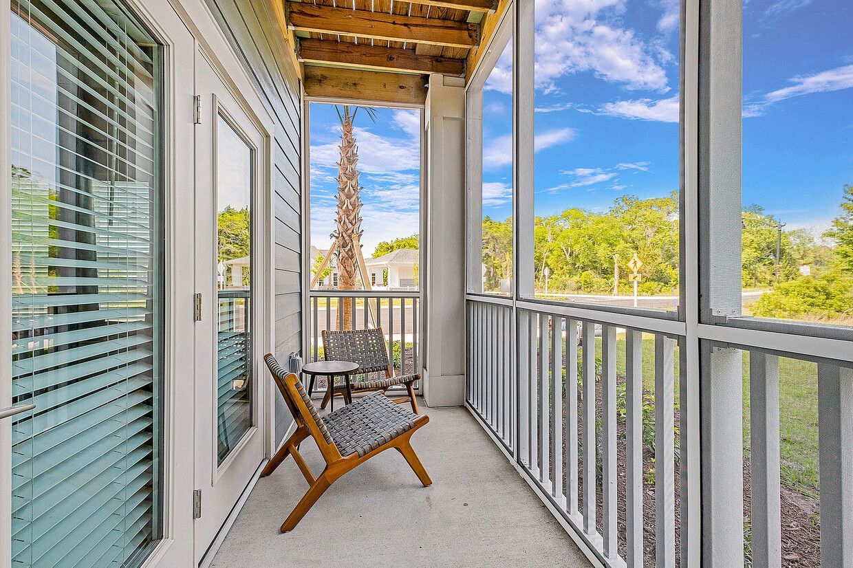 There is a screened in porch with a chair and table.