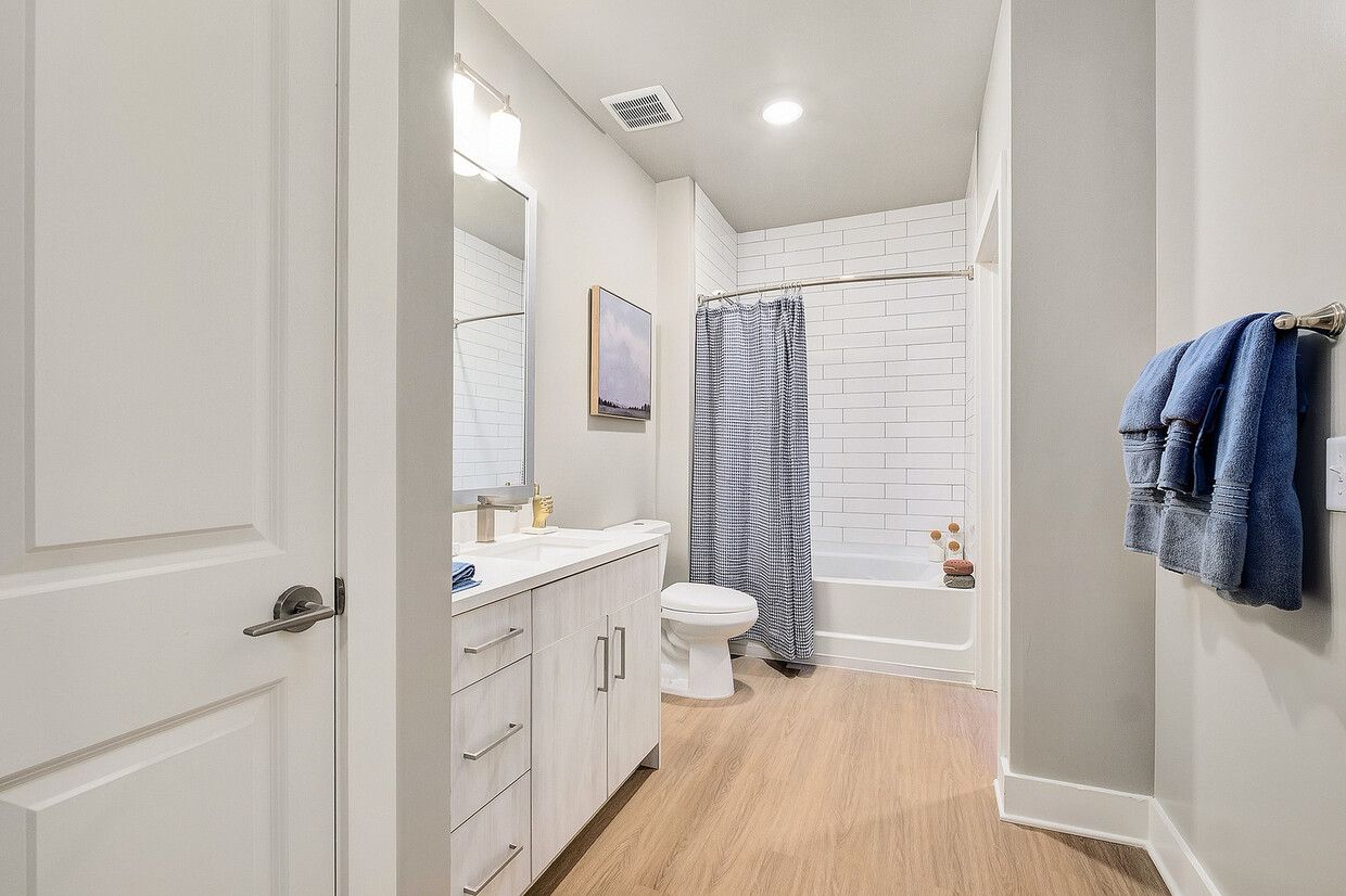A bathroom with a toilet , sink , and shower.