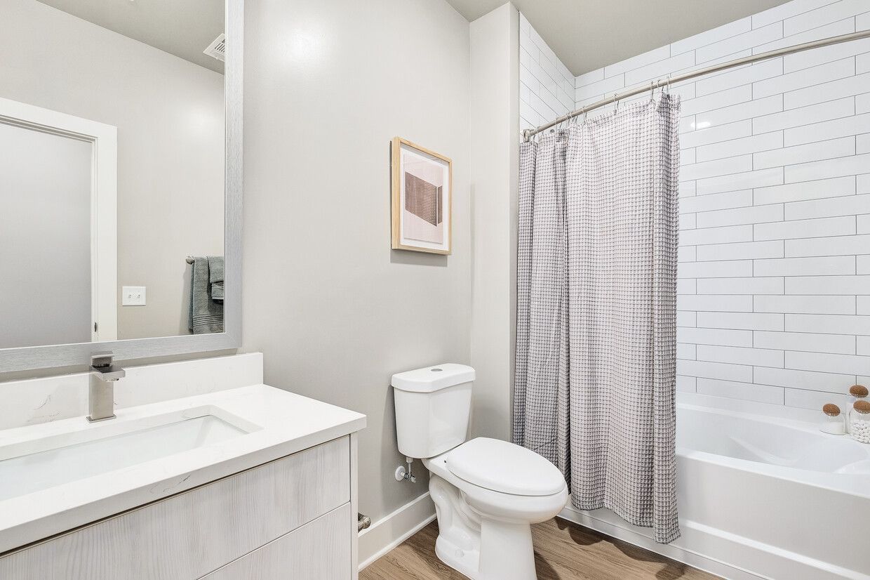 A bathroom with a toilet , sink , and shower.