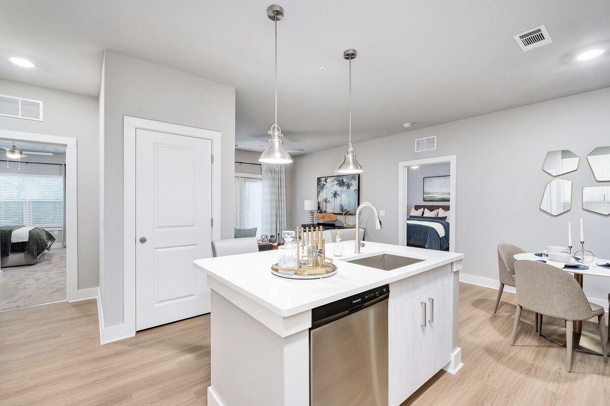 A kitchen with a large island and a stainless steel dishwasher.