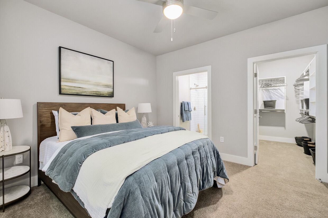 A bedroom with a king size bed and a walk in closet.