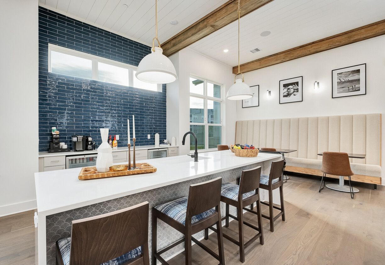 A kitchen with a long island , stools and a couch.
