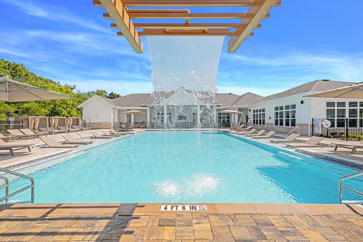 A large swimming pool with a fountain in the middle of it.