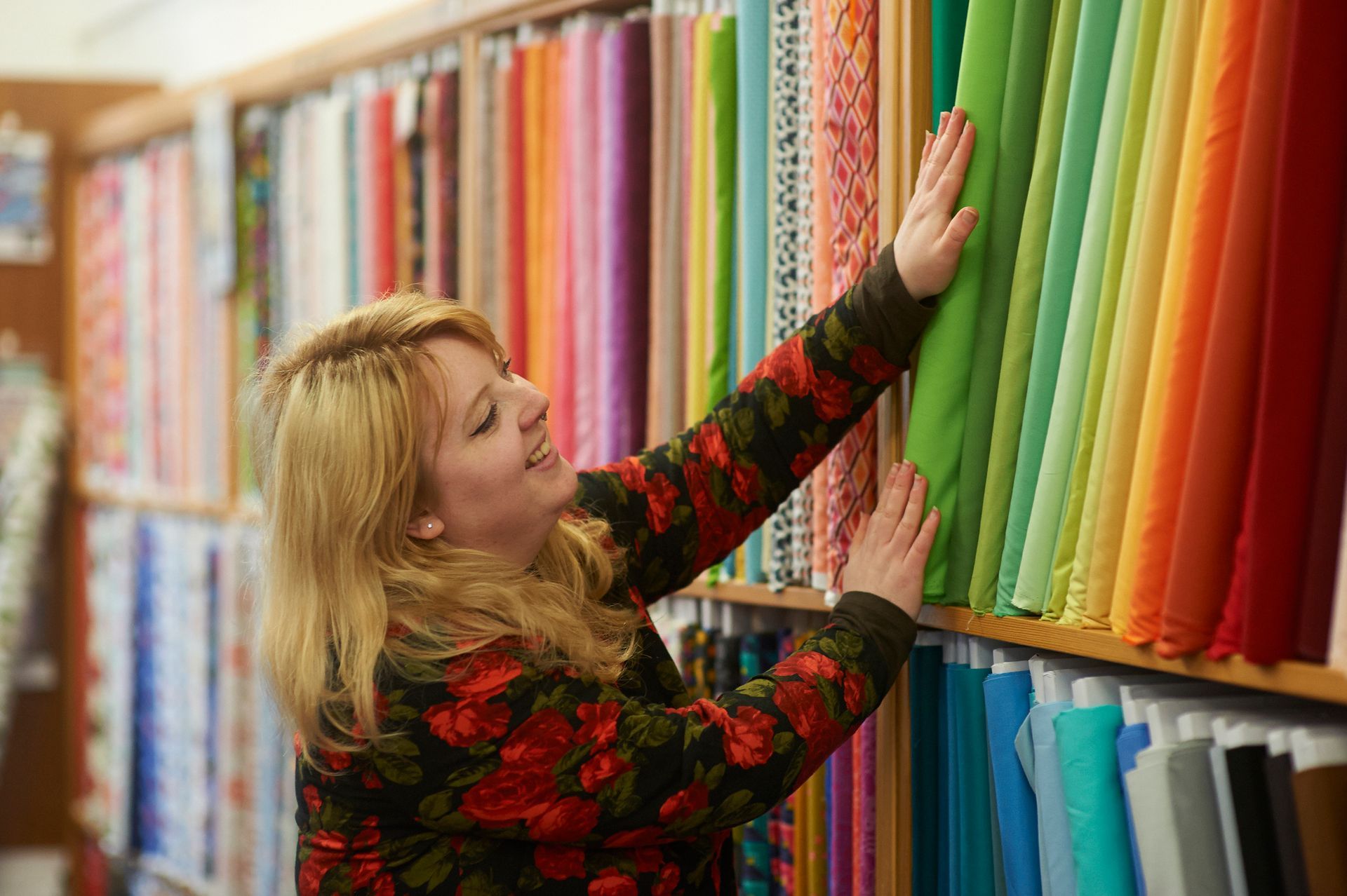 A woman choosing from a range of fabrics.