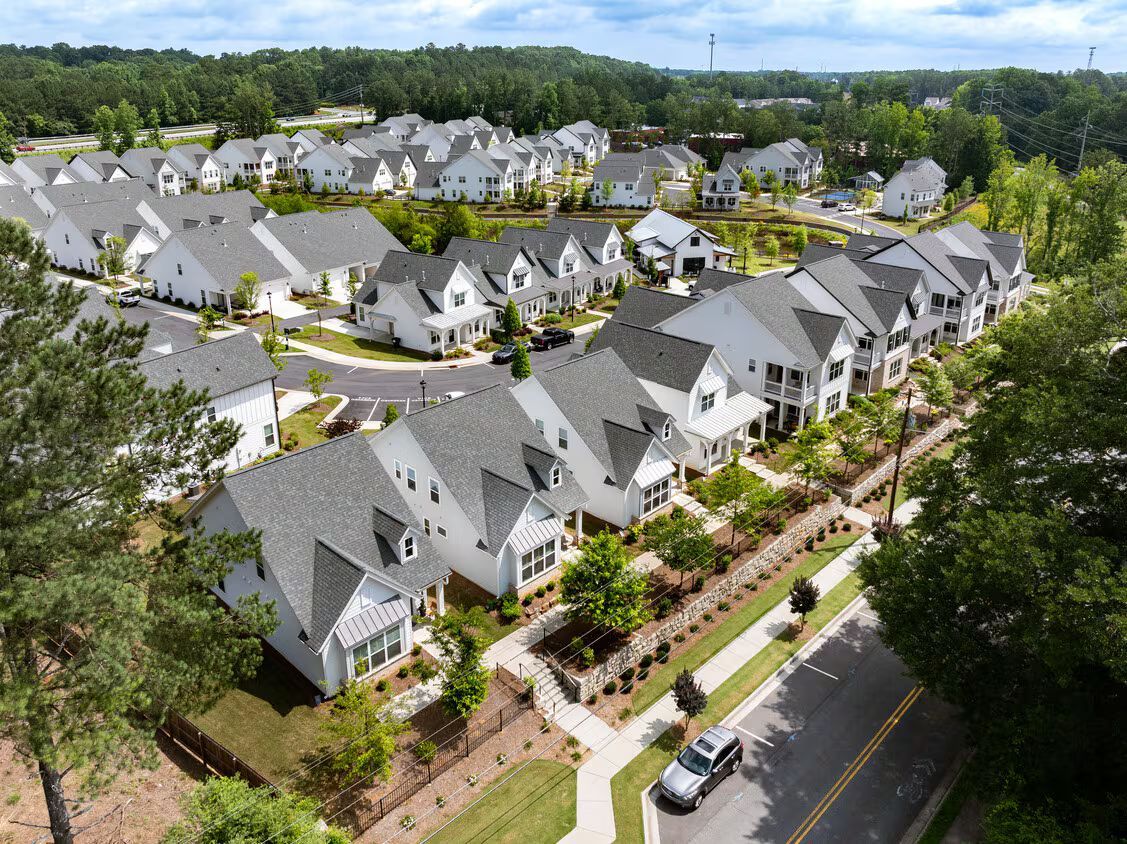A white house with a wooden roof and a wooden deck