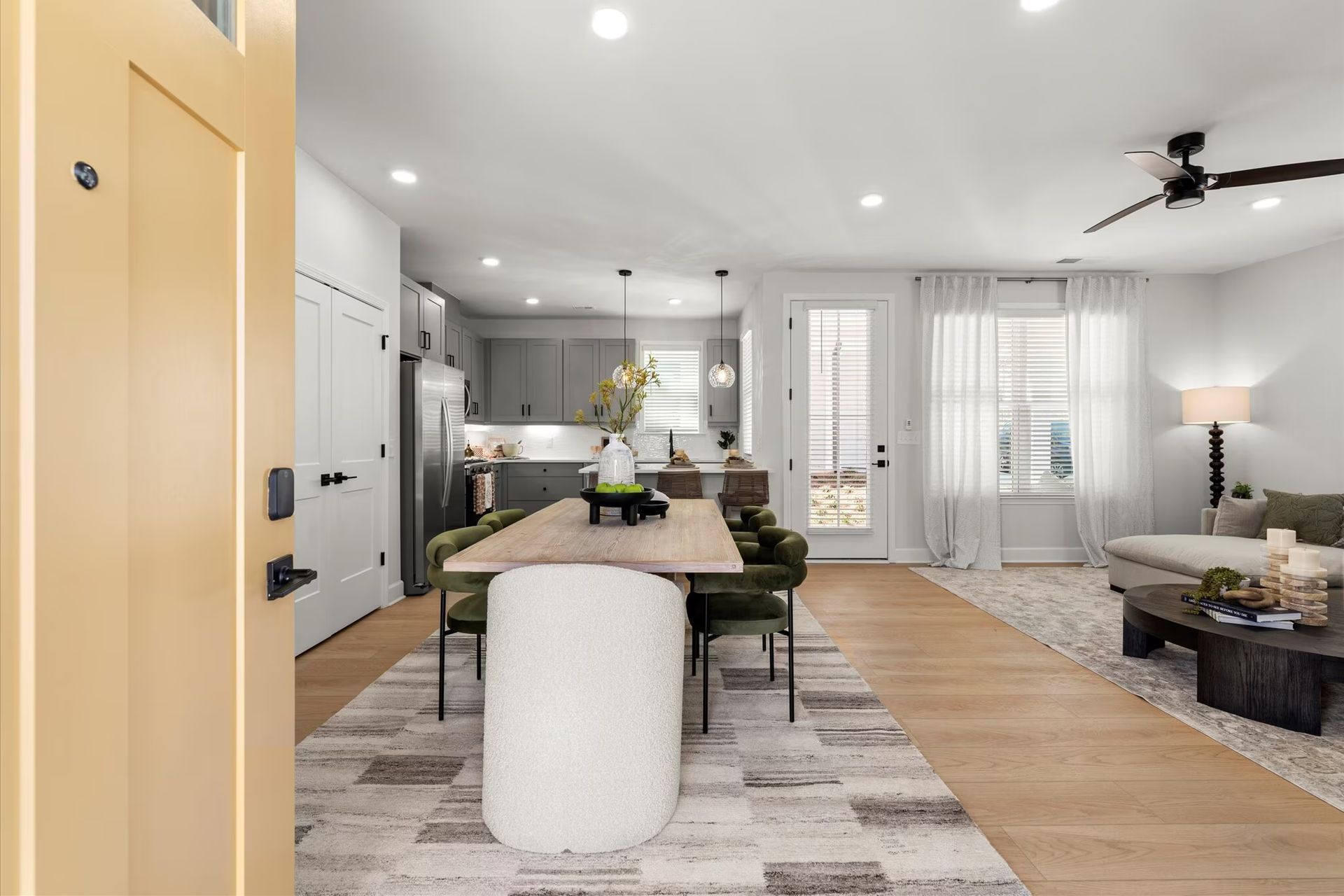 A living room with a table and chairs and a ceiling fan.