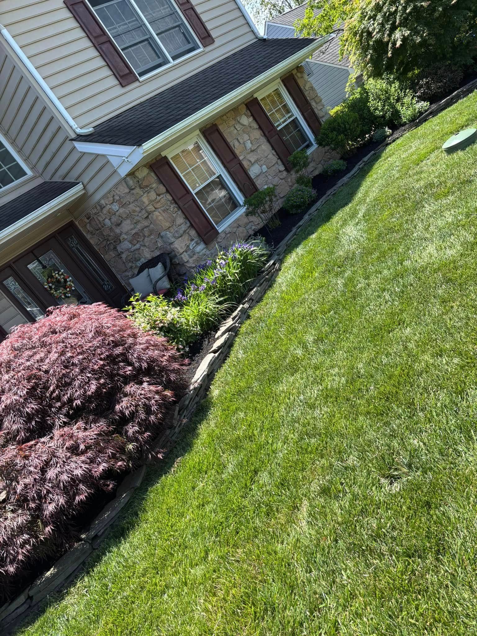House exterior with lush green lawn and colorful landscaping.