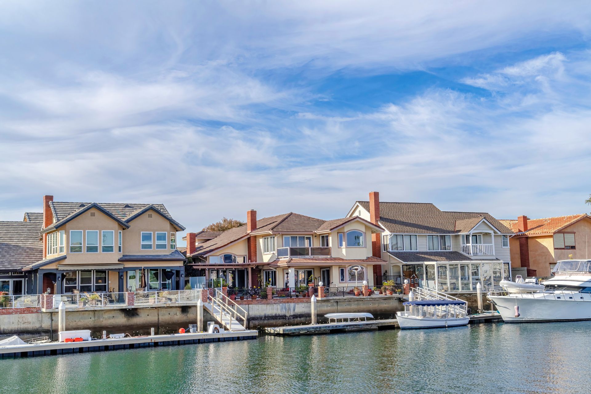A row of houses next to a body of water with boats docked. HOME ANALYSIS