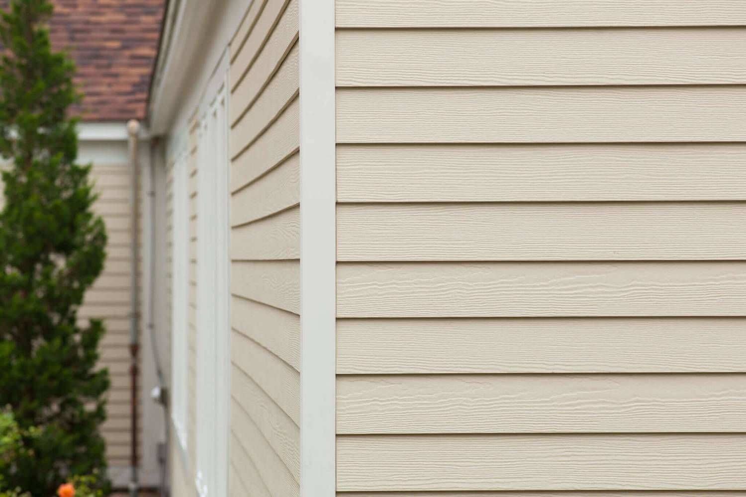 Beige, horizontal wood-grain siding on the corner of a residential building exterior.