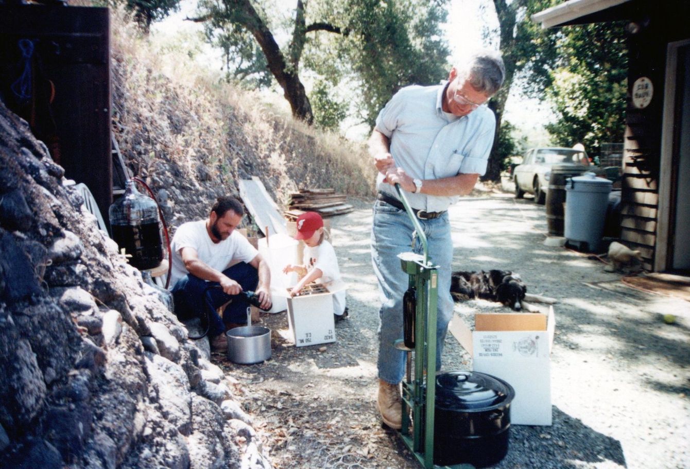 A man in a white shirt is using a machine outside
