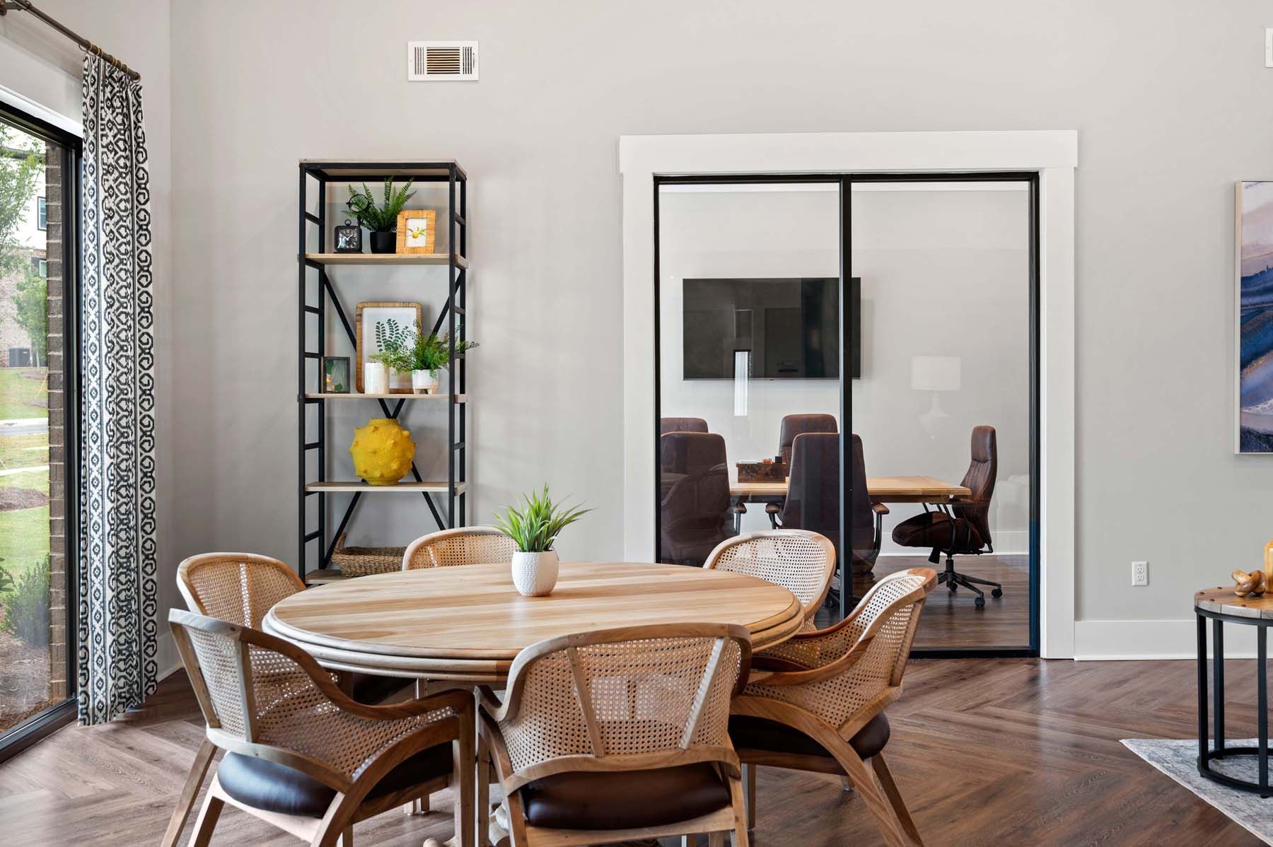 A dining room with a table and chairs and a television  at Pointe Grand Spring Hill.