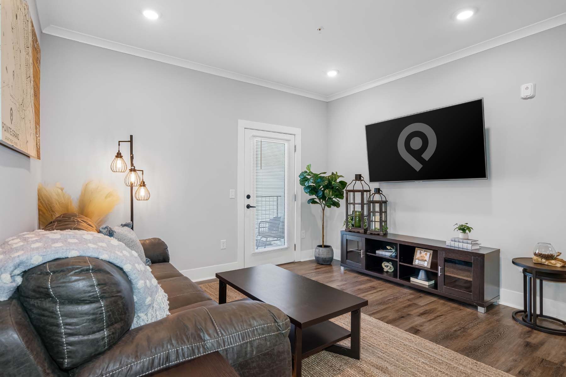 A living room with a couch , coffee table , and television  at Pointe Grand Spring Hill.