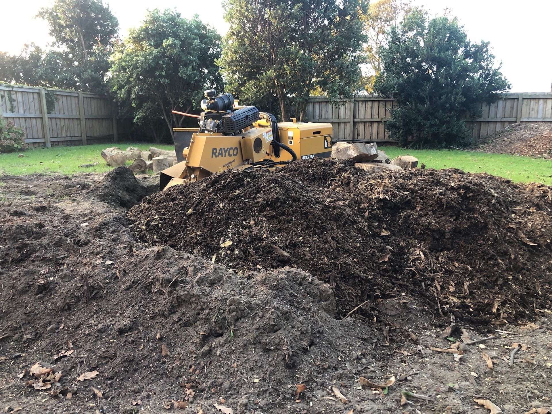 a yellow tractor is sitting on top of a pile of dirt .