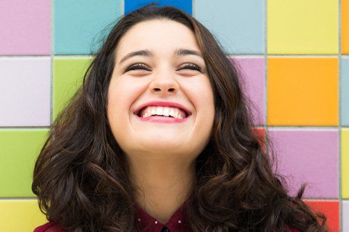 Happy Girl Leaning On Colorful Wall