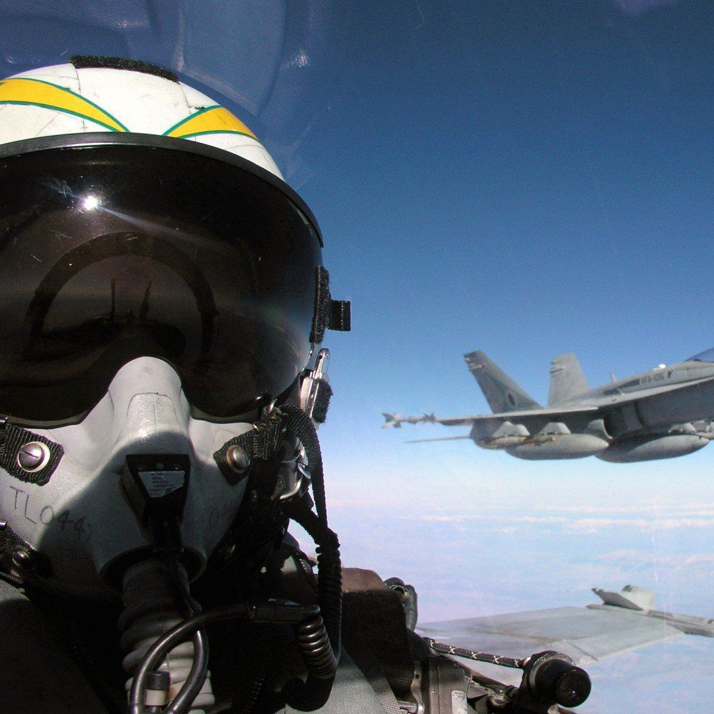 Fighter pilot in cockpit flying with F-18 on his wing