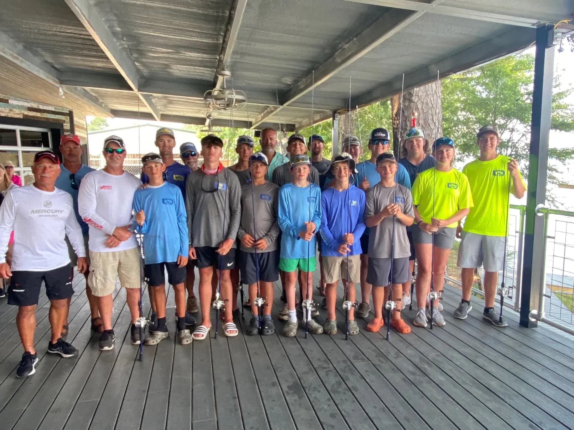 a group of young men are posing for a picture on a deck .