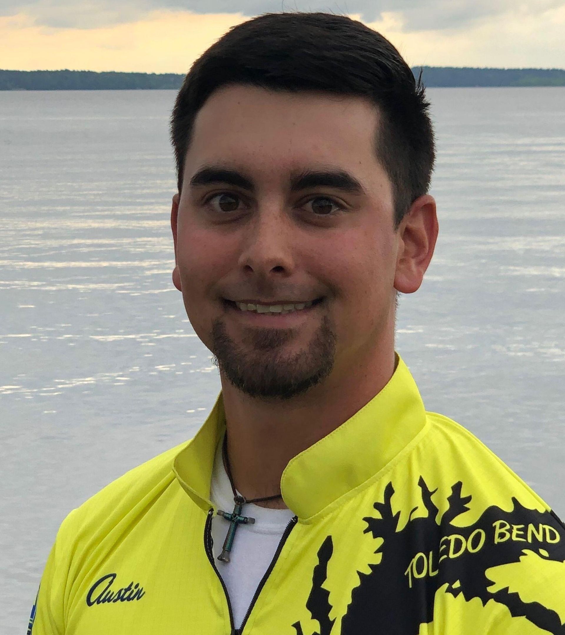 a man wearing a yellow toledo bend shirt smiles for the camera