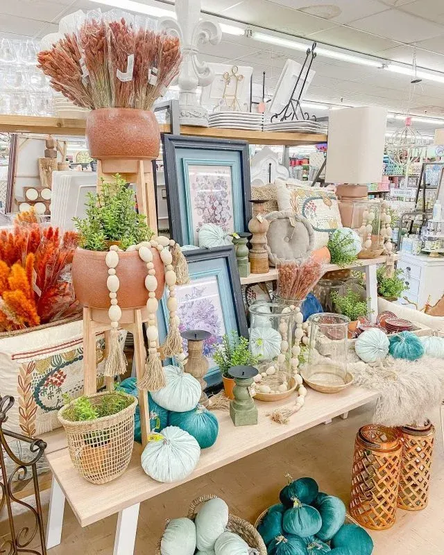 a table in a store filled with lots of decorations and plants .