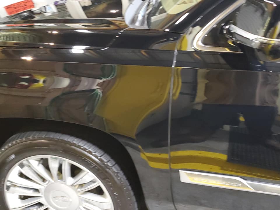 A black car with a yellow tag that says ' candy ' on it