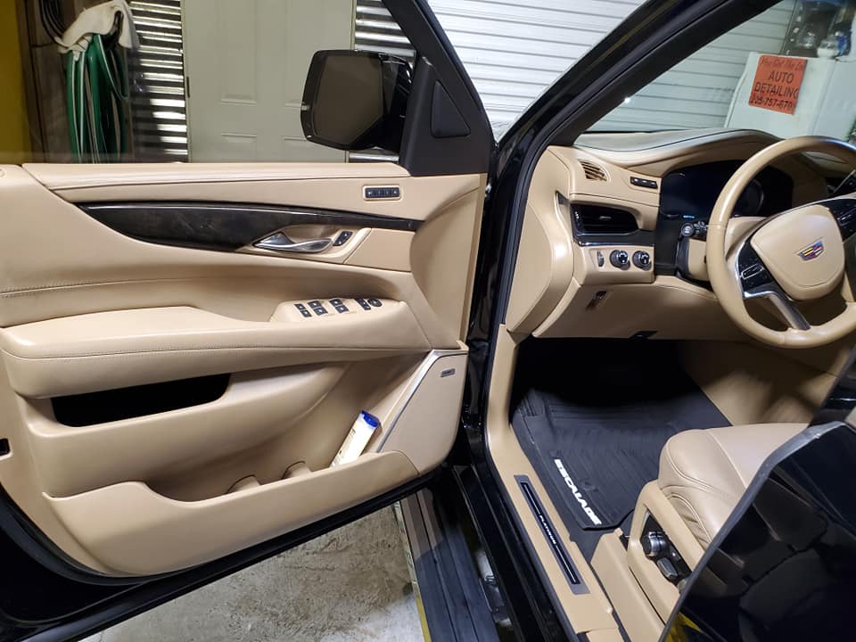 The inside of a black car with the door open