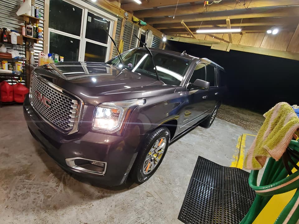 A gmc yukon is parked in a garage.