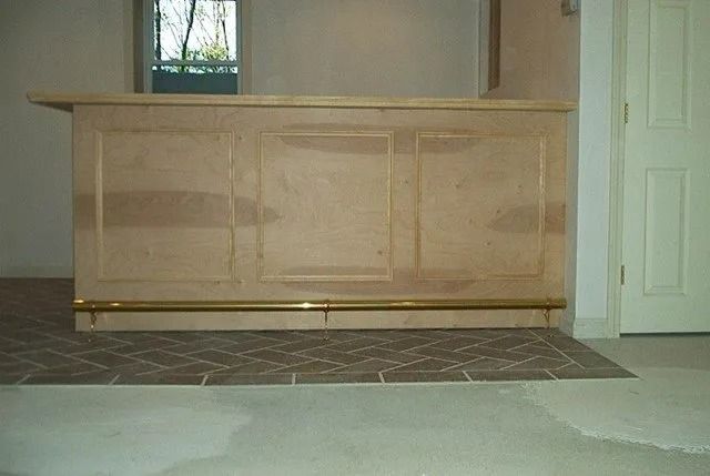 Wooden reception counter in a room with tiled floor and white doors