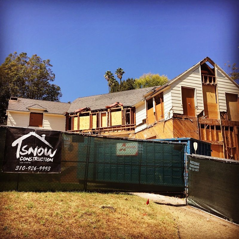 A house under construction with a sign that says tsnow construction