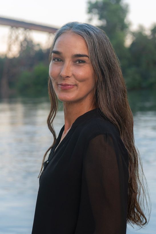 Charree Richey A woman is in front of a bridge next to river.
