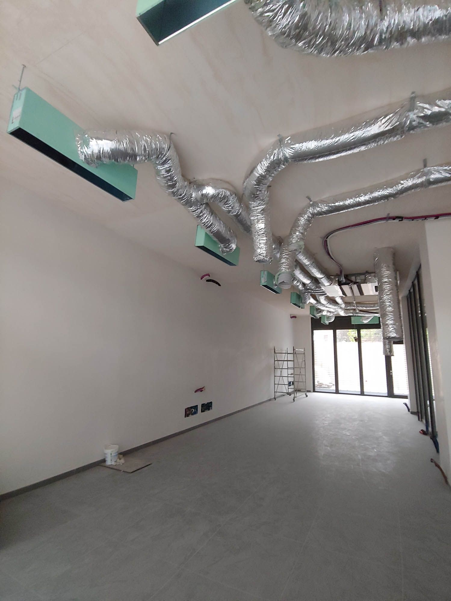 un edificio in costruzione con molti tubi metallici attaccati al soffitto .