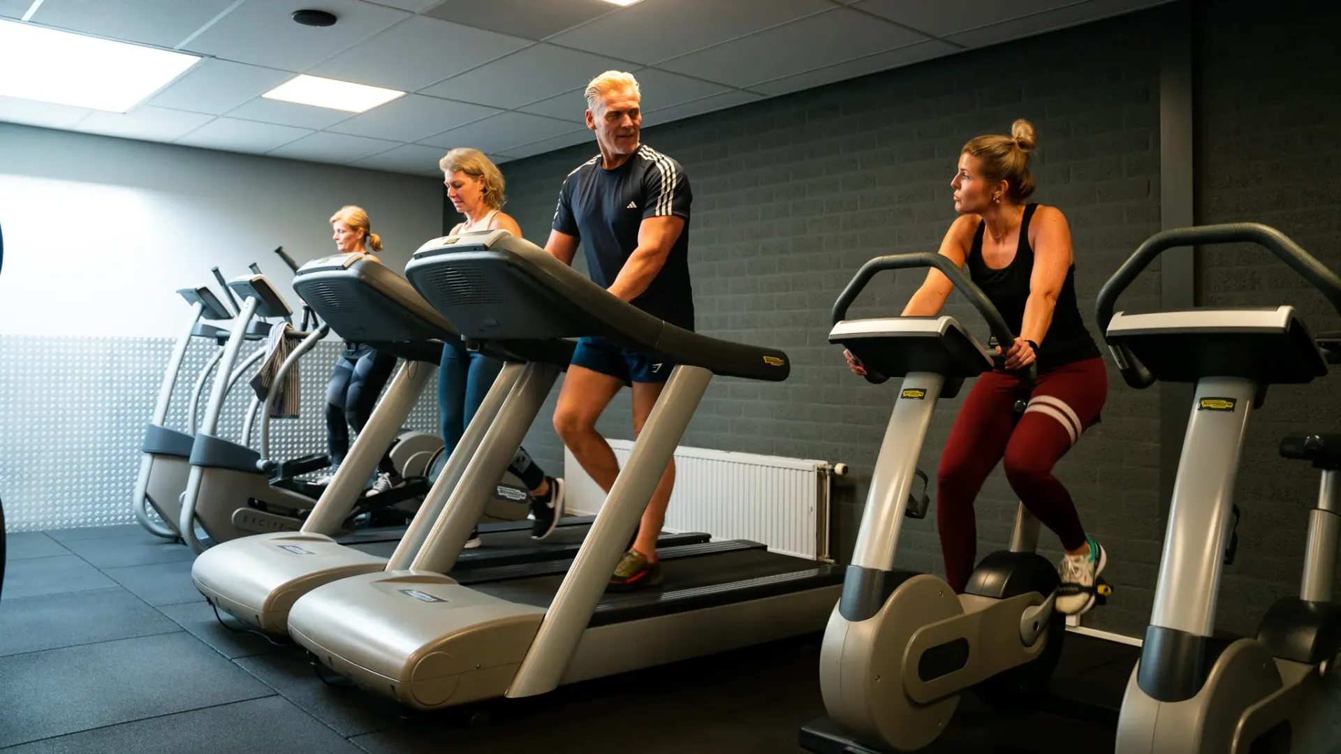 Een groep mensen rent op loopbanden in een sportschool.