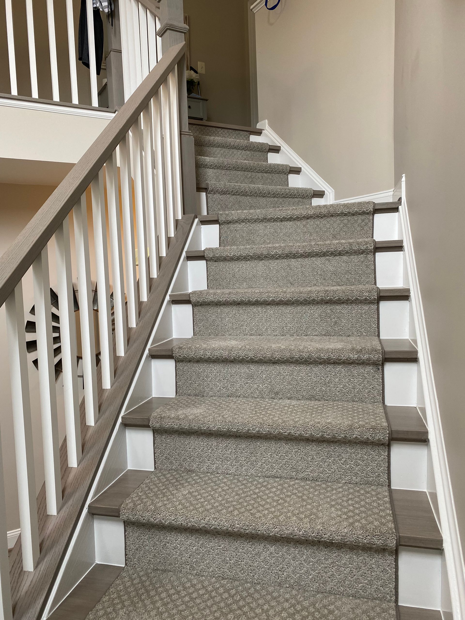 A staircase with a carpeted floor and a white railing.