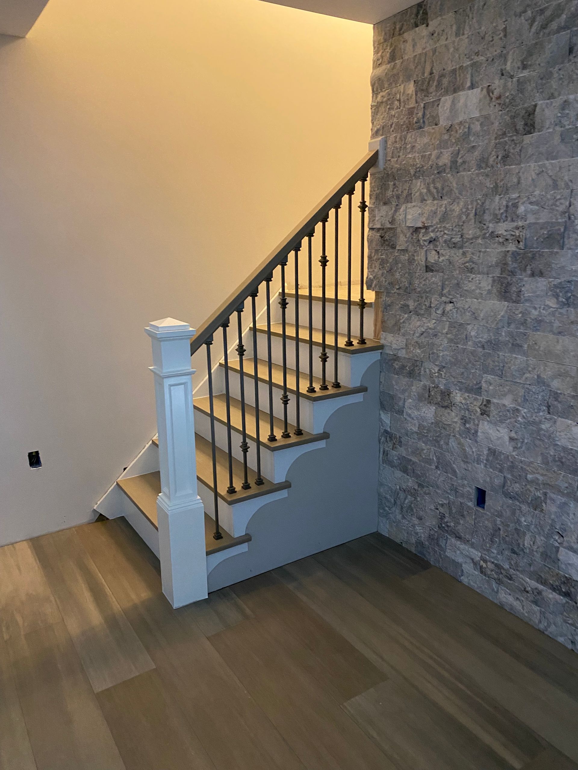 A staircase with a stone wall behind it