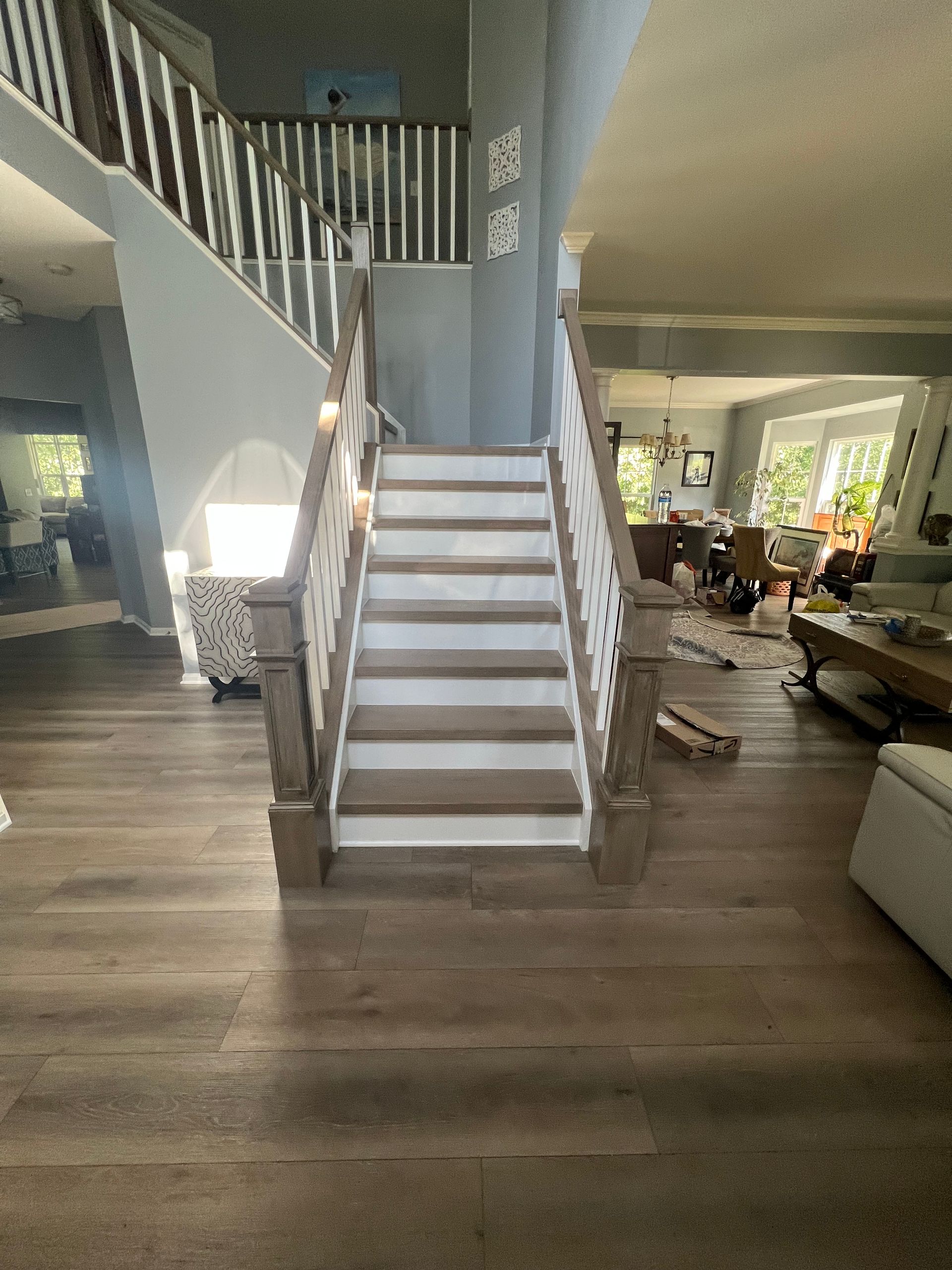 A staircase in a living room with a white railing.