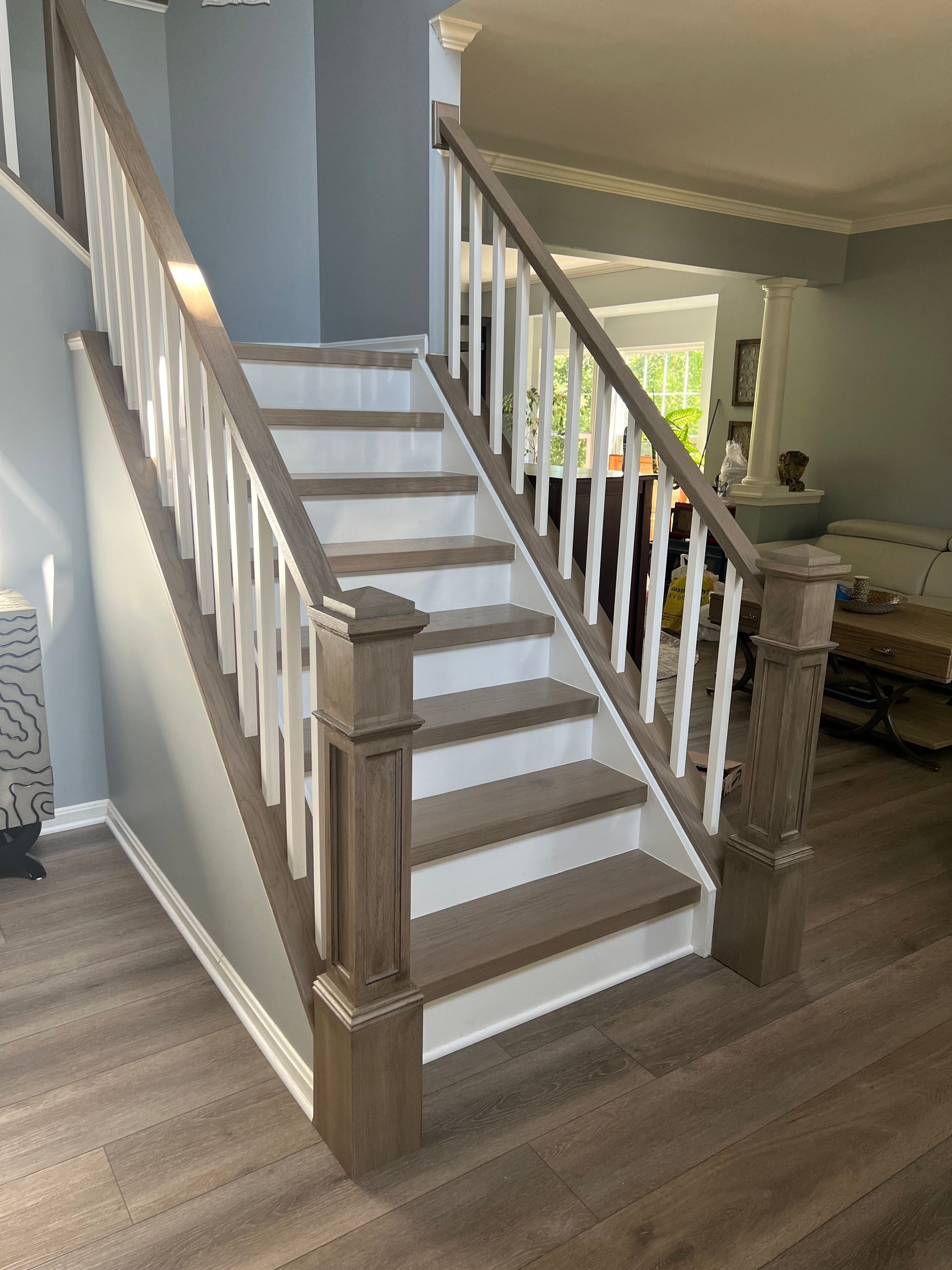 A wooden staircase with a white railing in a living room.