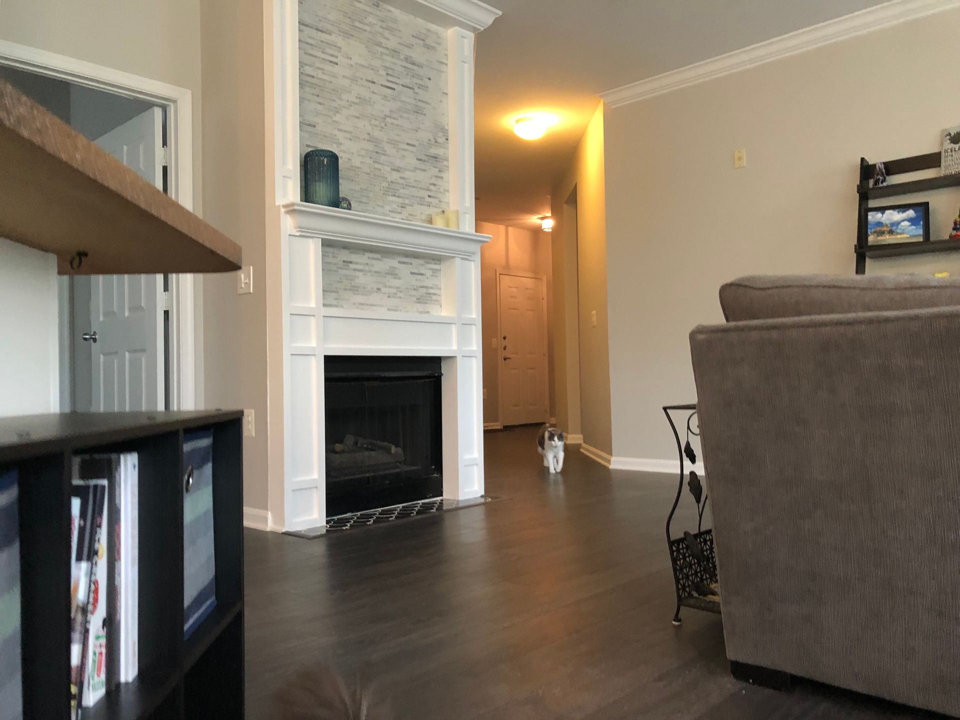 A living room with a fireplace , couch , chair and bookshelf.