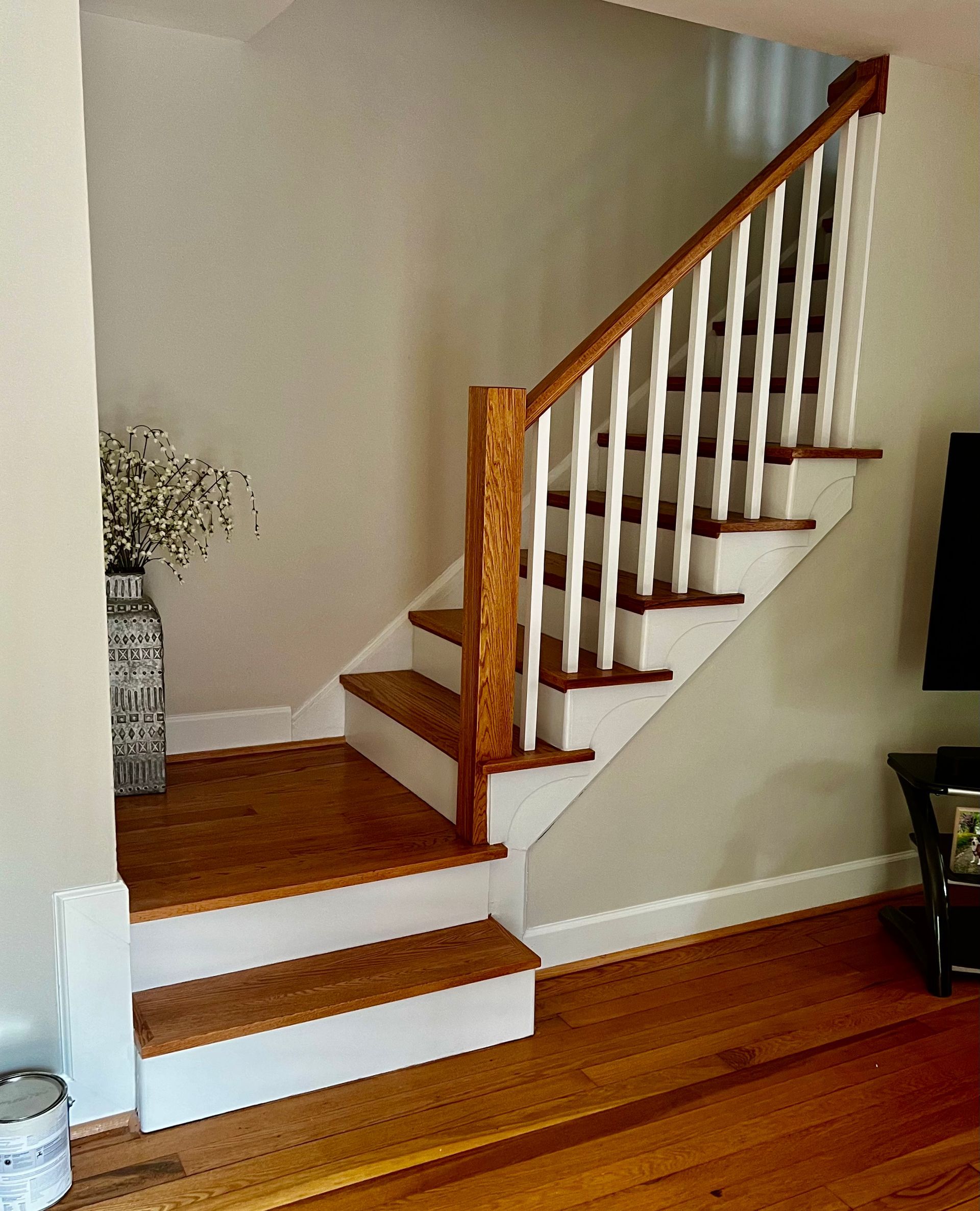 A wooden staircase with a white railing in a living room