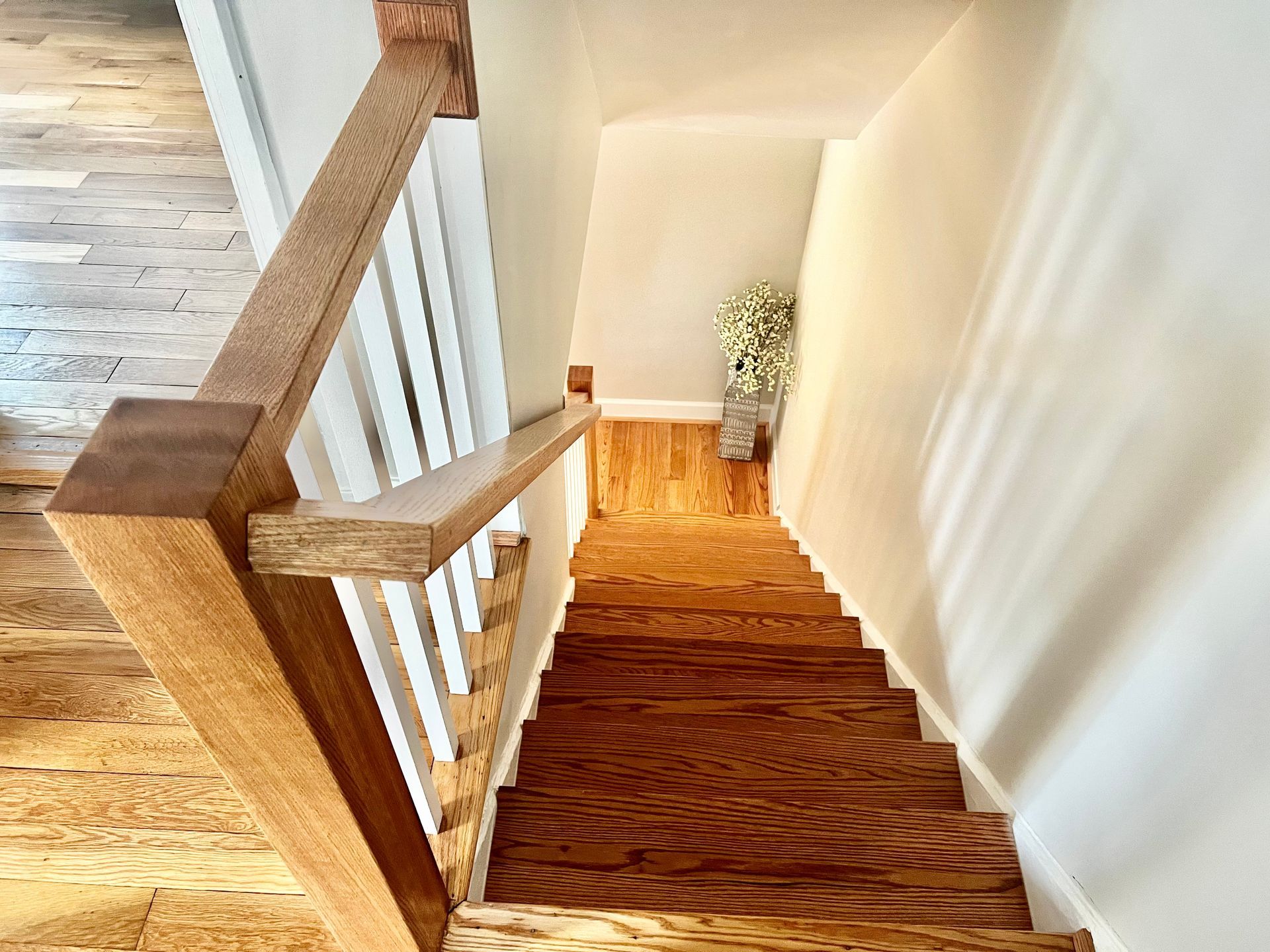 A wooden staircase with a white railing leading up to the second floor of a house.
