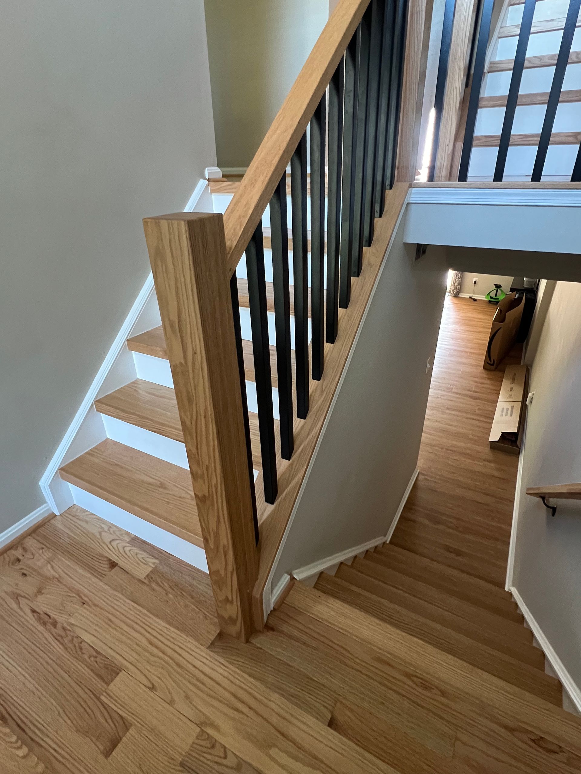 A wooden staircase with a black railing in a house.