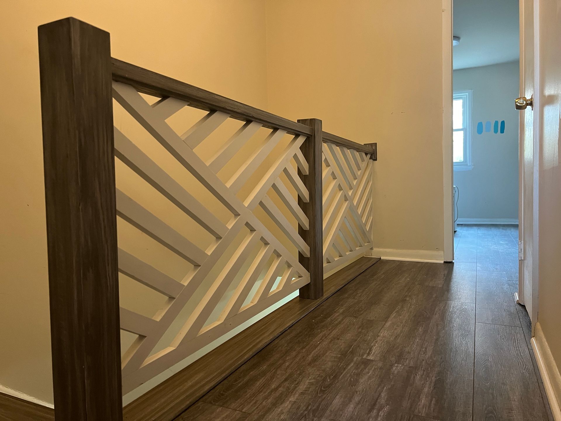 A hallway with a wooden railing and a wooden floor